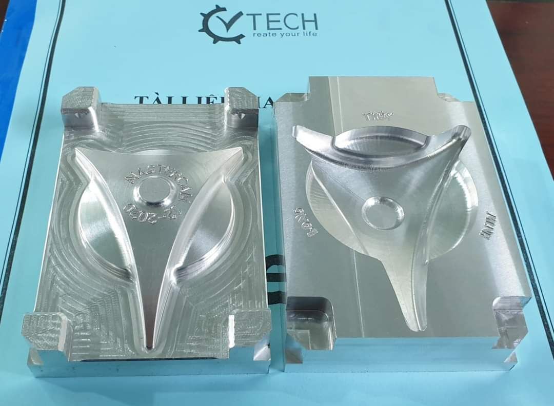 Cặp khuôn nhôm phay đặt cạnh nhau trên nền xanh, có logo CVTECH - gia công xung điện