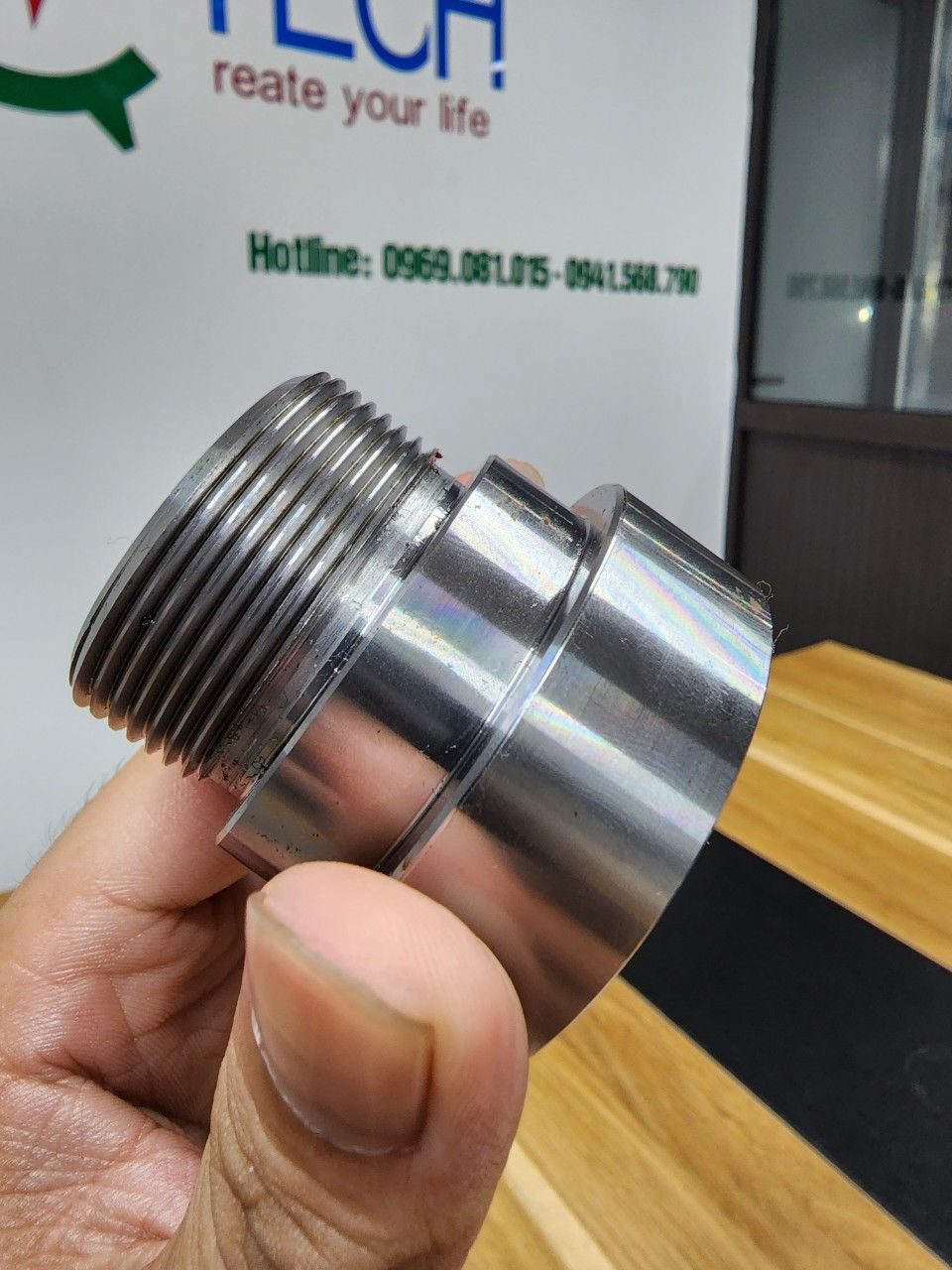 Chi tiết thép tiện có ren cầm trên tay - gia công ren
