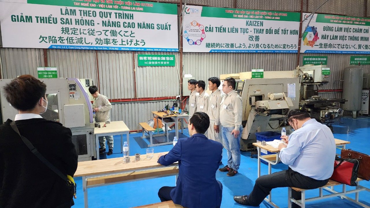 Nhóm người ngồi và đứng quan sát trước máy phay CNC trong xưởng - tuyển dụng tại pmtt group