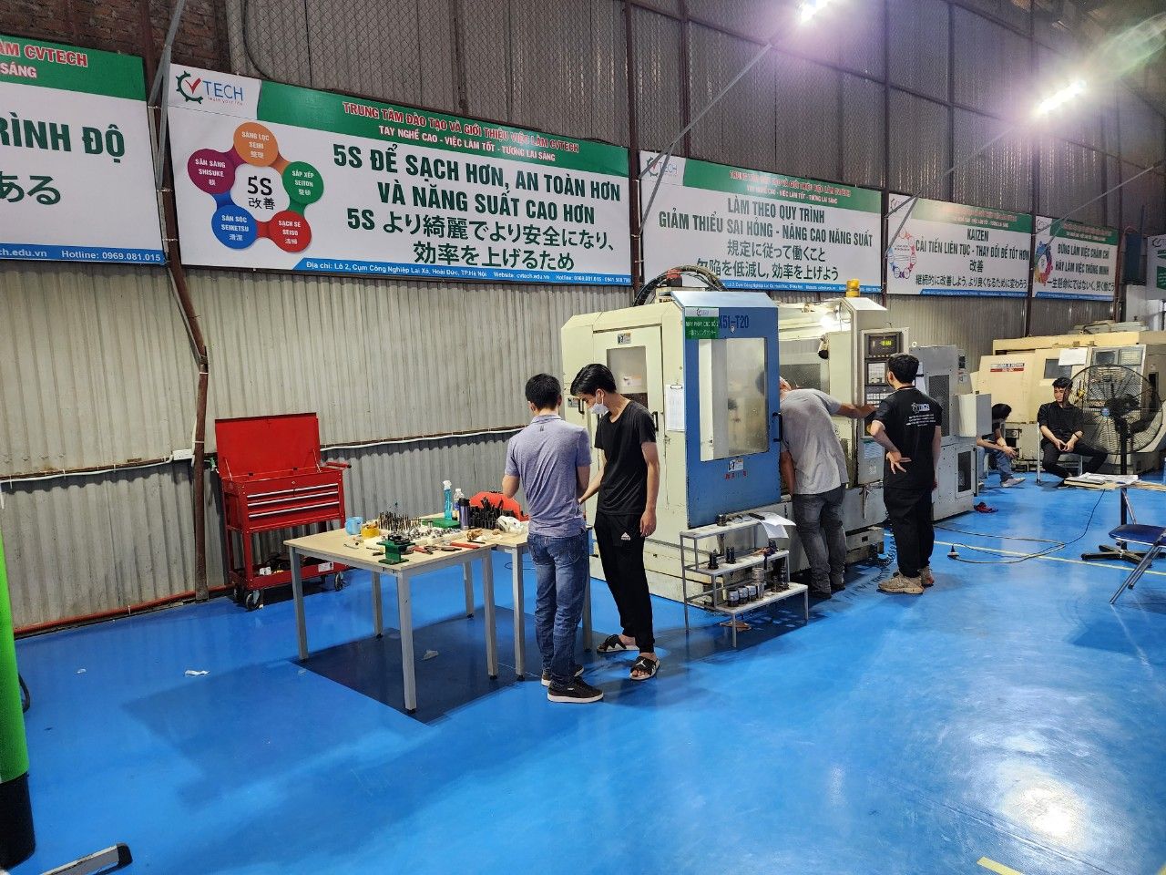 Học viên đứng quanh máy phay CNC trong xưởng - hệ tọa độ máy cnc
