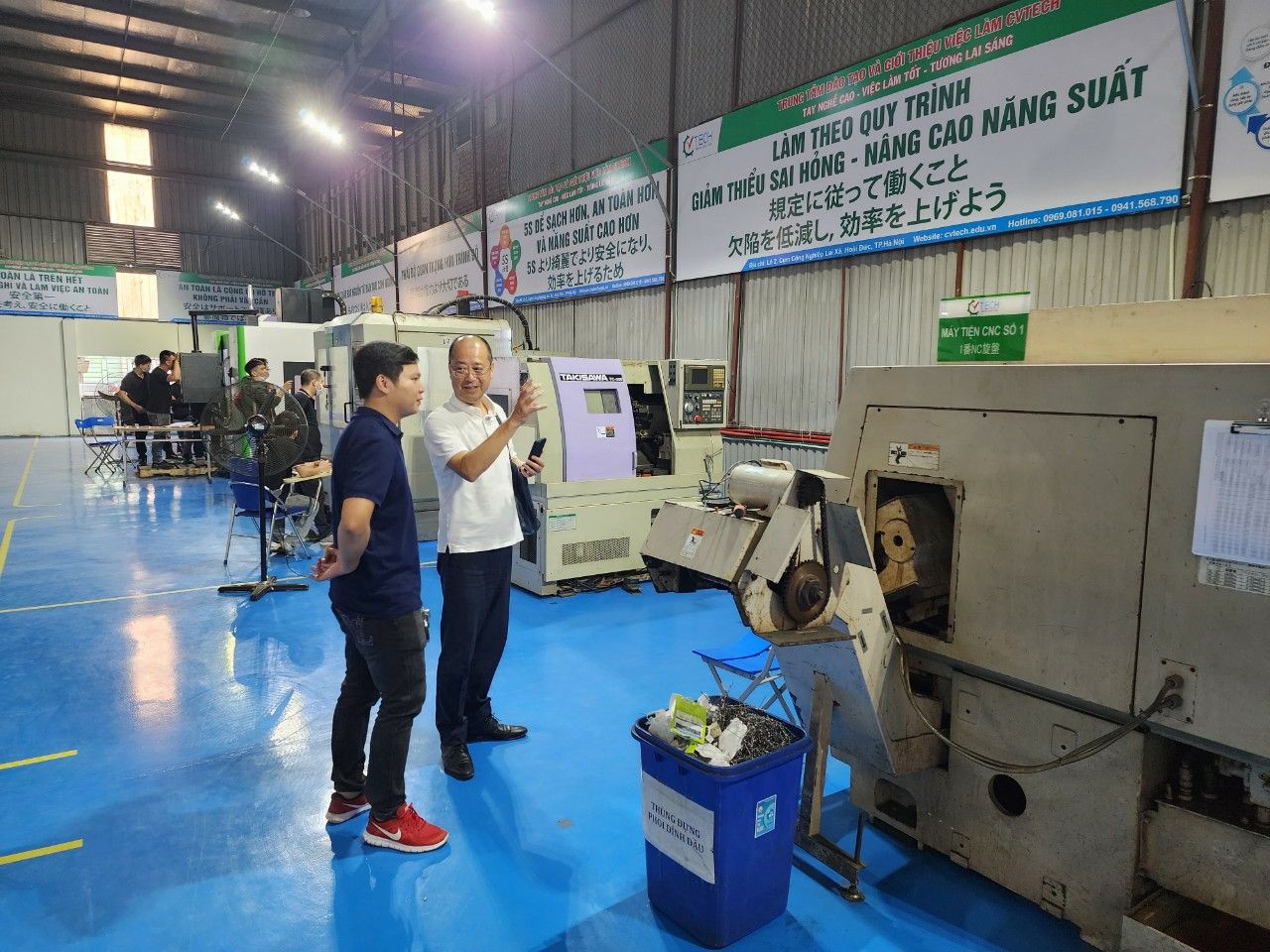 Nhóm học viên đứng bên máy tiện trong xưởng - học nghề ngắn hạn