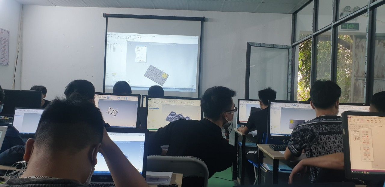 Học viên ngồi máy tính trong phòng học, màn chiếu phía trước - học lập trình cnc