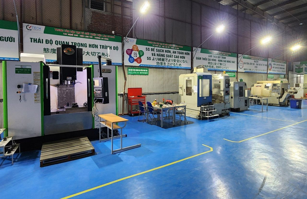 Toàn cảnh xưởng buổi tối, máy phay CNC và sàn epoxy xanh - học nghề cơ khí ngắn hạn