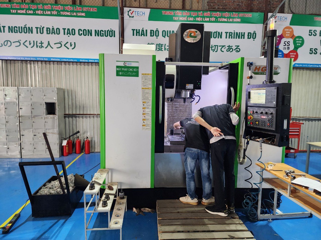 Hai học viên gá phôi trong buồng máy phay CNC số 1 của xưởng - gá phôi và đo phôi trên máy phay cnc