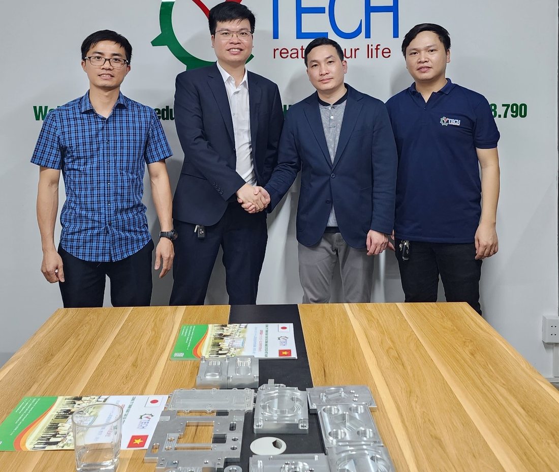 Bốn người mặc vest bắt tay trước phông logo CVTECH, bàn gỗ có sản phẩm mẫu - tuyển dụng tại công ty semitsu việt nam