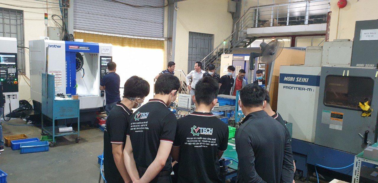 Nhóm học viên mặc đồng phục CVTECH giữa các máy