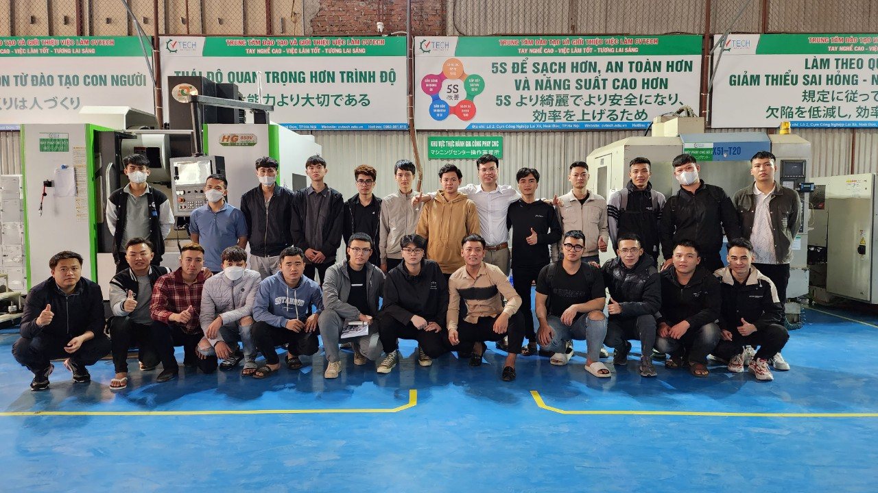 Ảnh tập thể một lớp khoảng 25 học viên trong xưởng