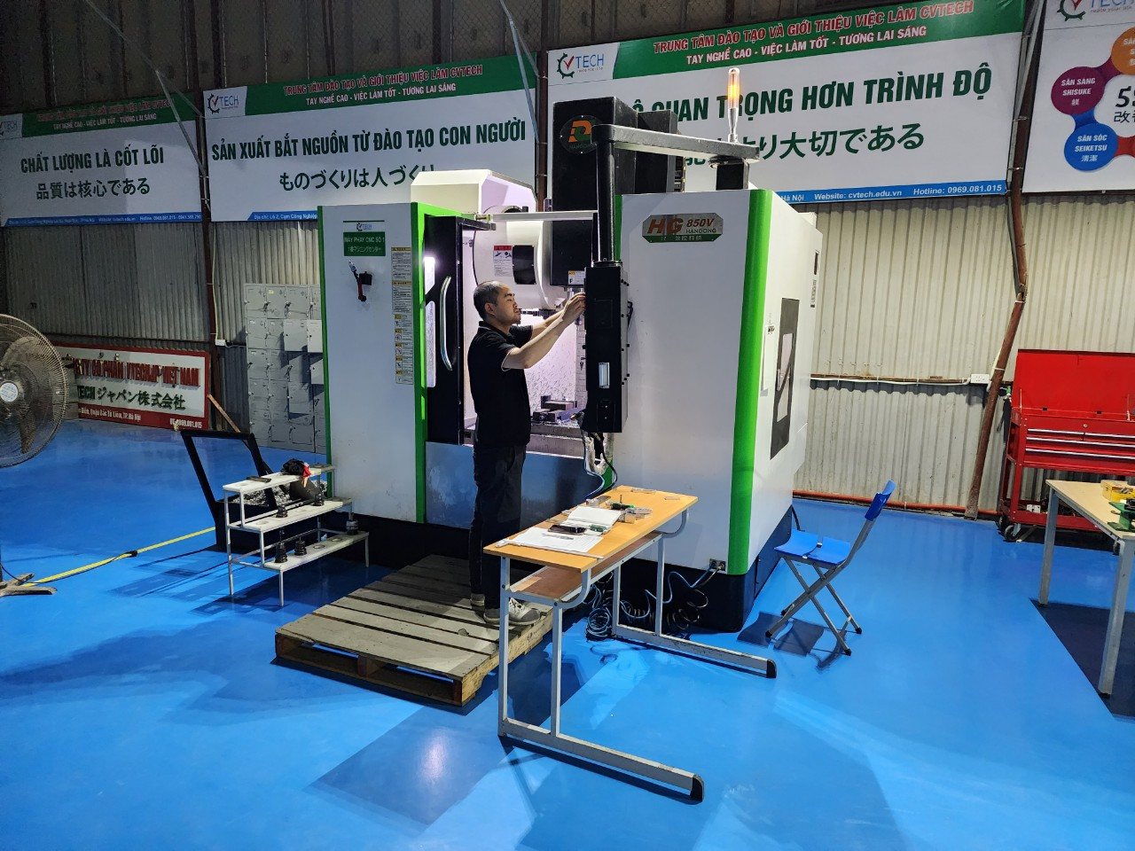 Học viên thao tác bảng điều khiển máy phay CNC tại xưởng CVTECH