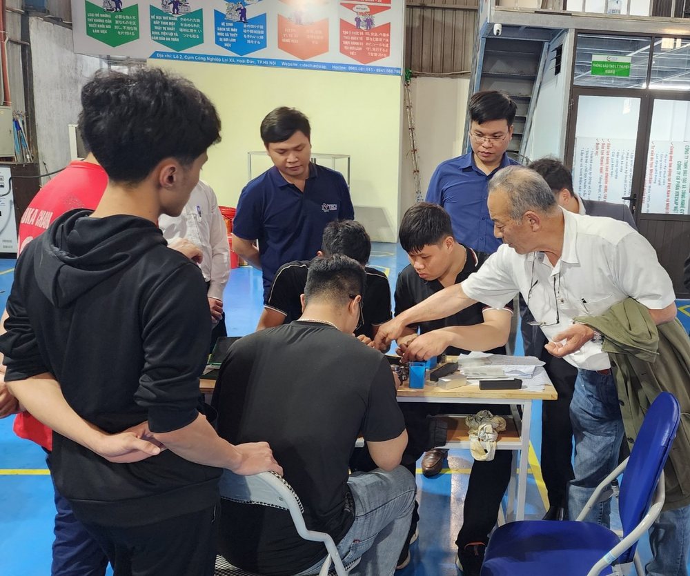 Giảng viên hướng dẫn nhóm học viên quanh bàn thực hành