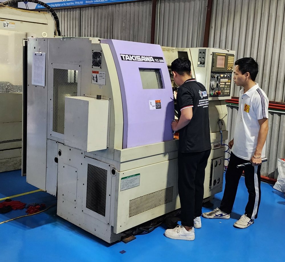 Hai học viên bên máy tiện CNC tại xưởng